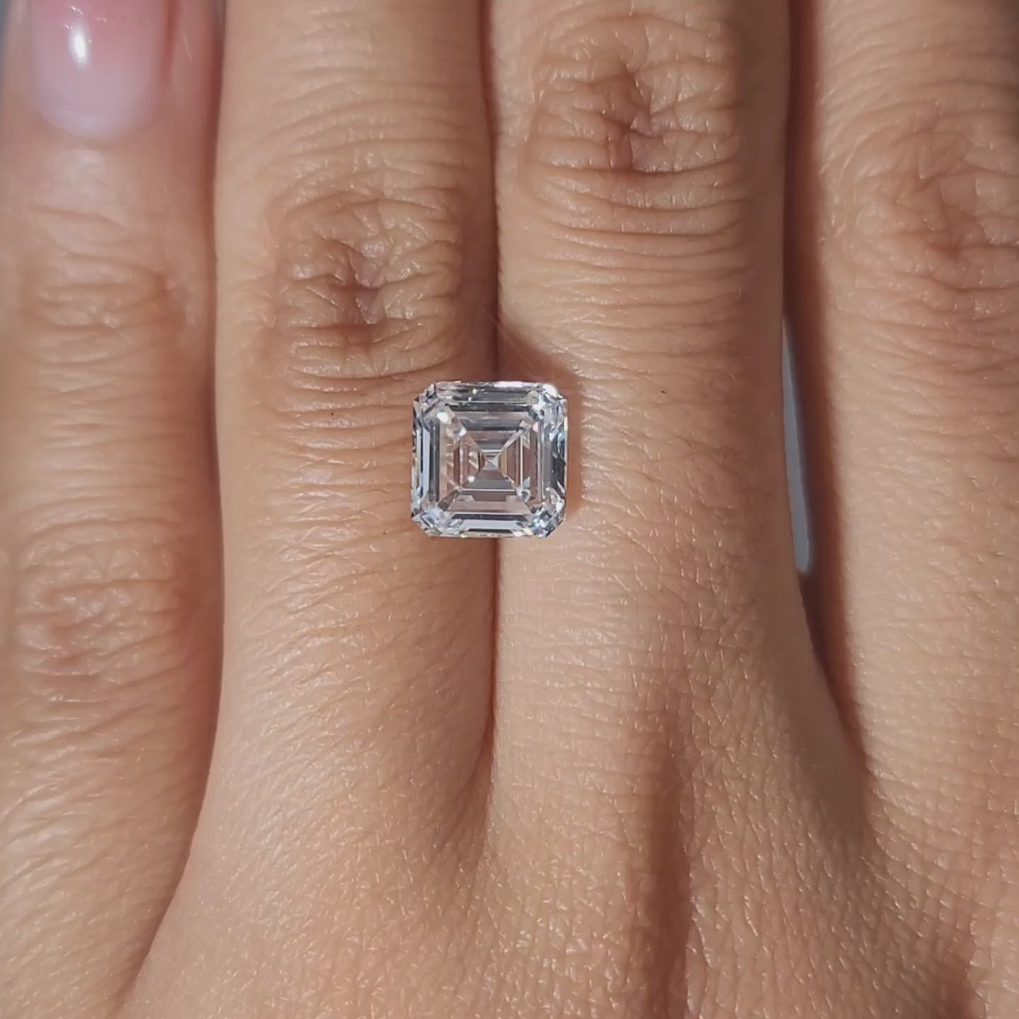 Finger-worn video of 2.54ct Asscher diamond in warm glow