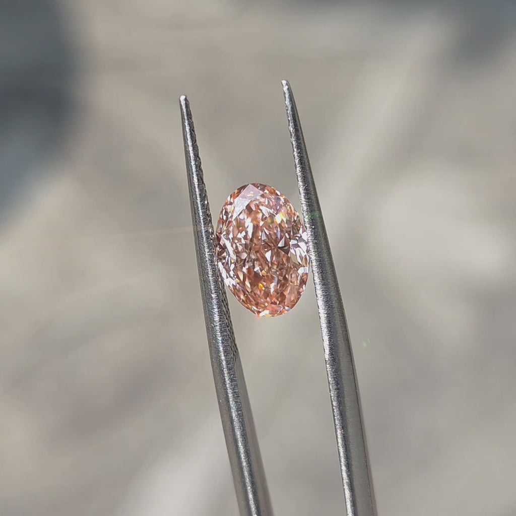 A 2.14ct oval brilliant cut fancy vivid pink VVS1 lab diamond sparkles in sunlight.