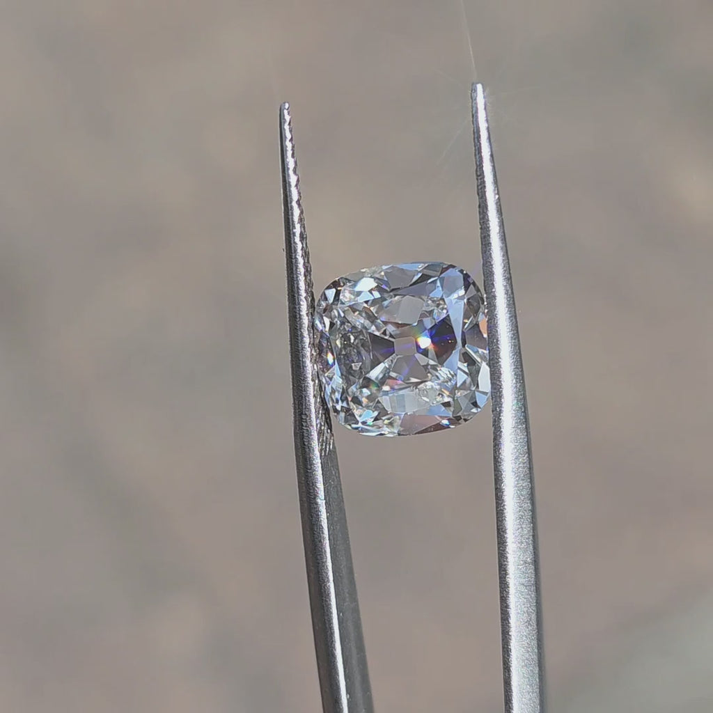 Outdoor sunlight reveals the fire of a 5.01ct cushion old mine cut lab diamond.