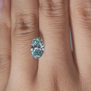 Hand-modeled close-up of 1.762ct blue oval diamond in warm indoor lighting
