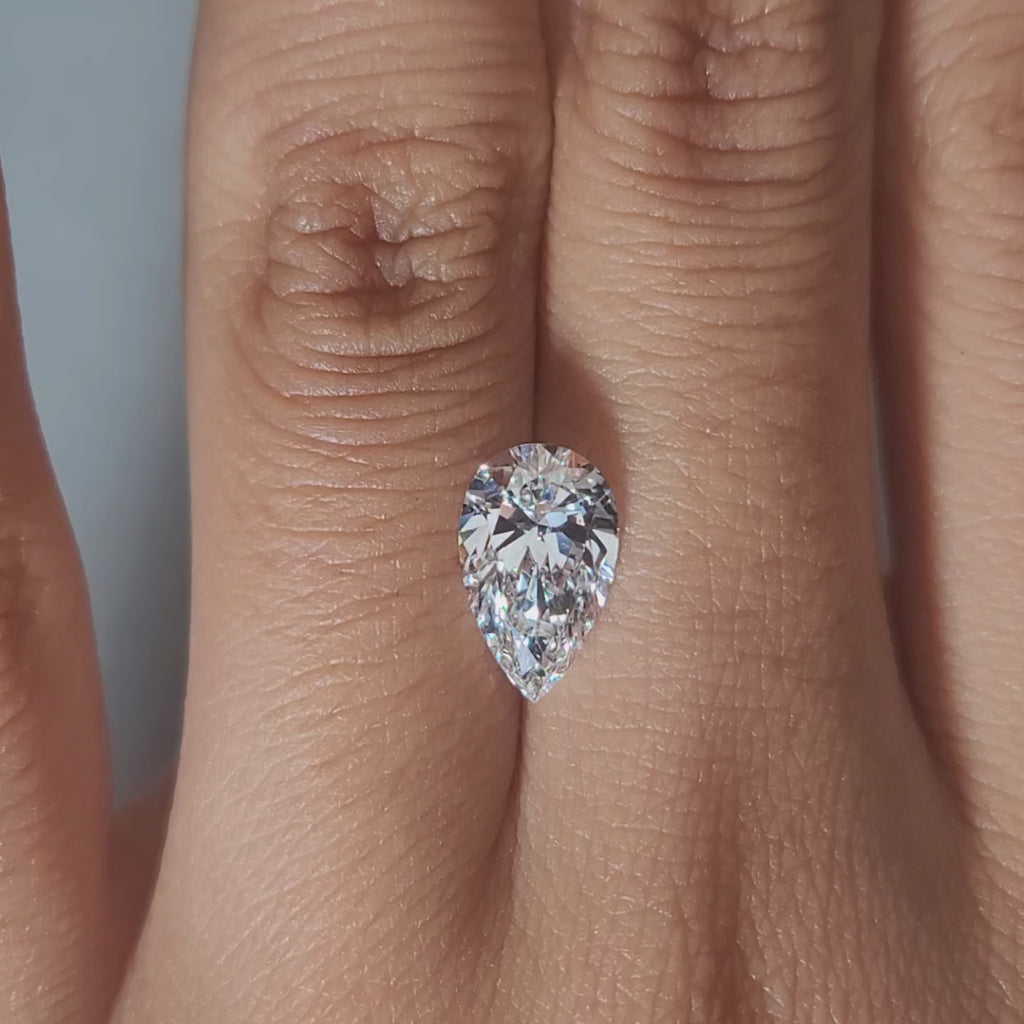 Close-up hand video of 1.72ct pear diamond in cozy indoor lighting
