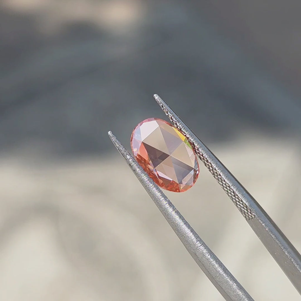 1.75ct oval rose cut fancy vivid pink VVS1 lab diamond showing soft pink glow in outdoor sunlight.