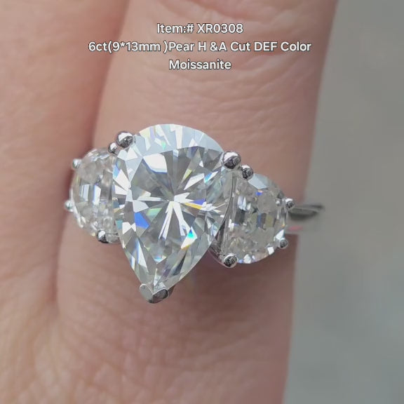 DovEggs 6ct Pear moissanite engagement ring with half moon moissanite side stone sparkling in sunlight video.