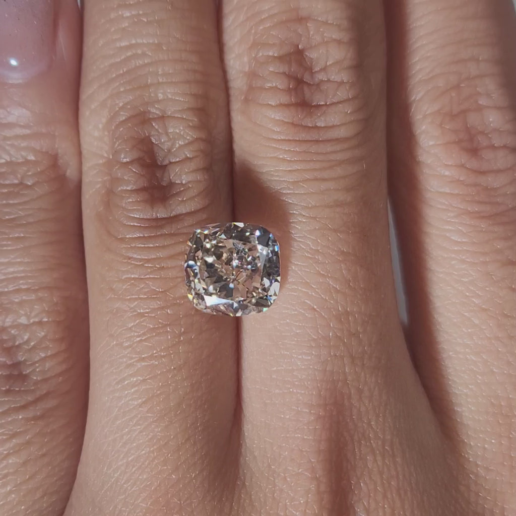 "Hand-modeled video of 3.546ct cushion diamond in warm indoor lighting"