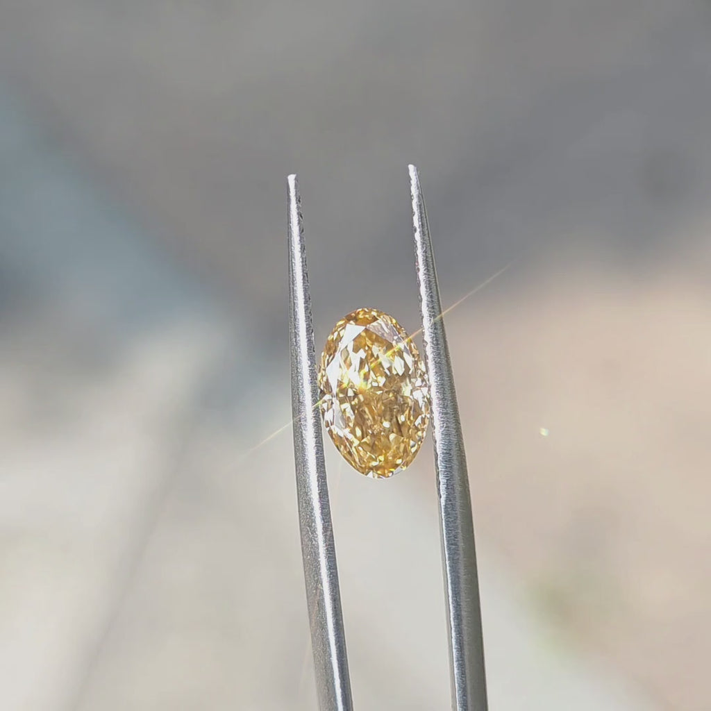 Sunlight enhances the brilliant yellow of a 2.09ct oval cut fancy vivid yellow lab diamond.