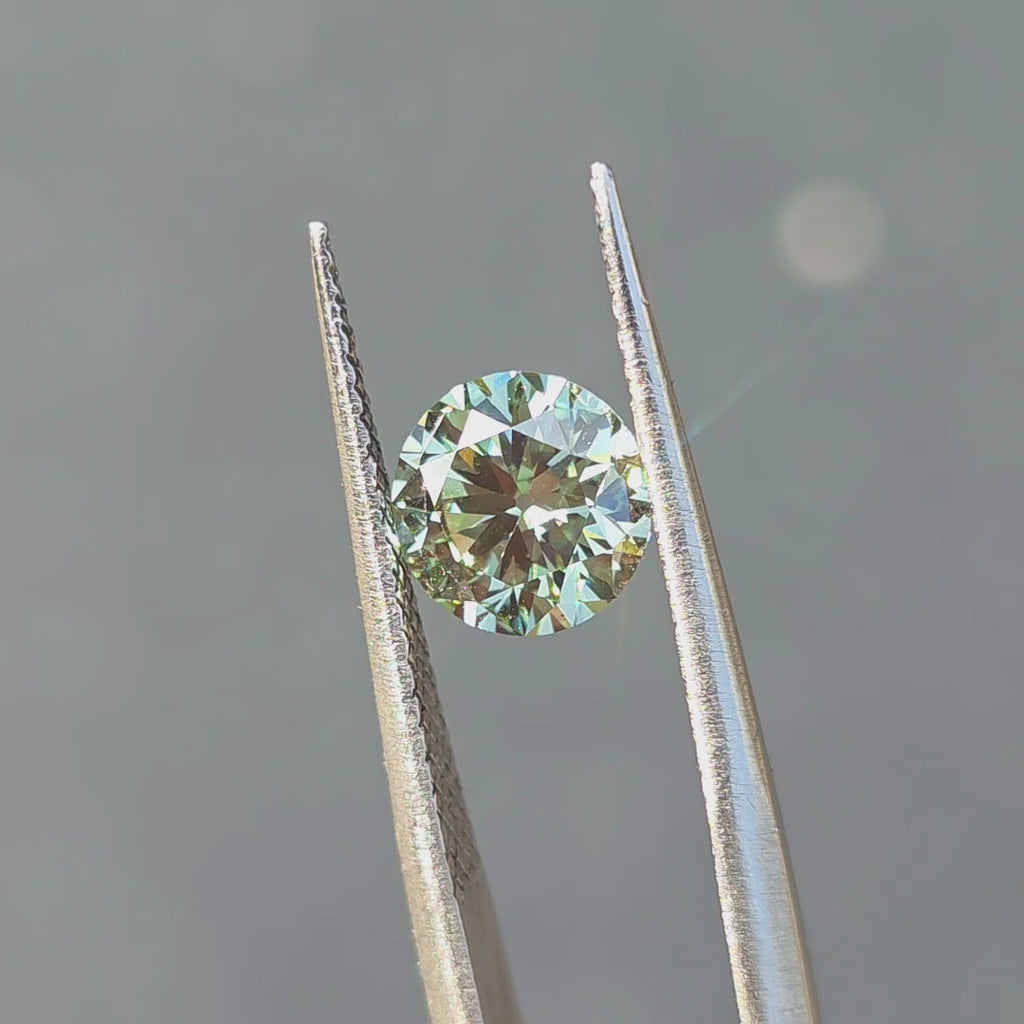 1.55ct round old European cut fancy vivid green VVS2 lab diamond displaying vintage sparkle in outdoor sunlight.