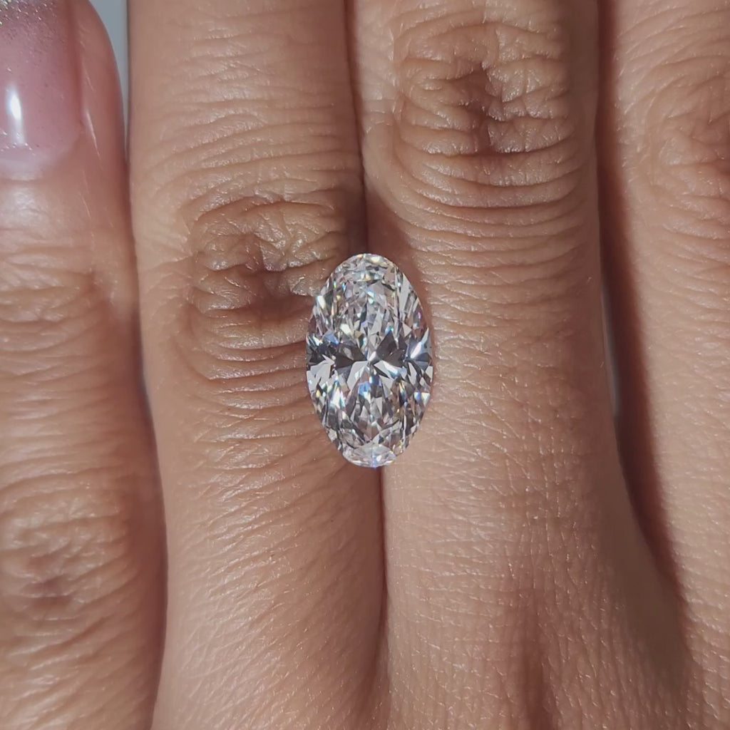 "Hand-modeled video of 3.212ct oval diamond in warm indoor lighting"