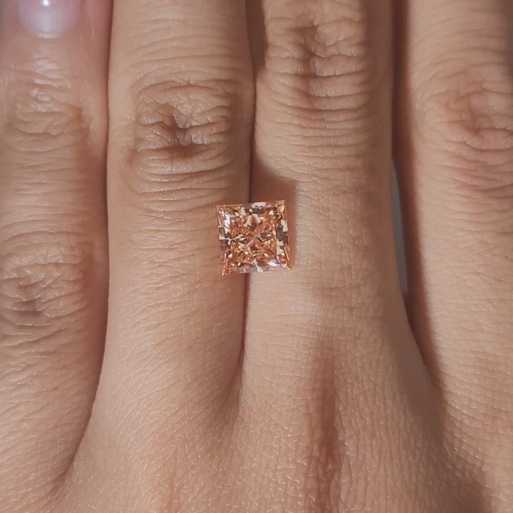 Close-up slow motion of 2.067ct princess cut diamond's brilliant facets under warm lighting