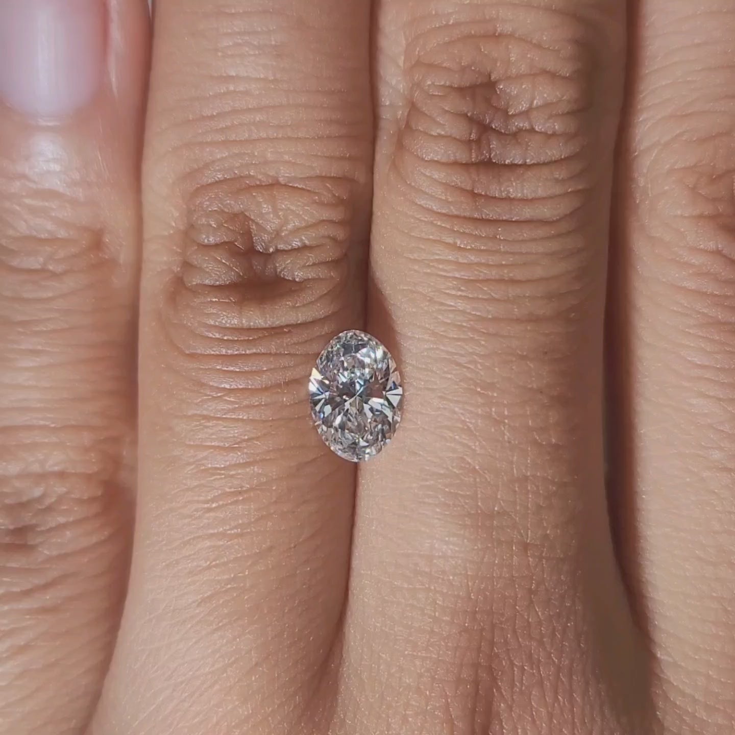 Close-up hand video of 1.02ct oval diamond in soft indoor lighting