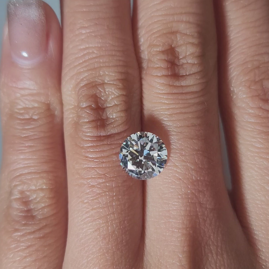 "Hand-modeled video of 2.548ct round diamond in warm indoor lighting"