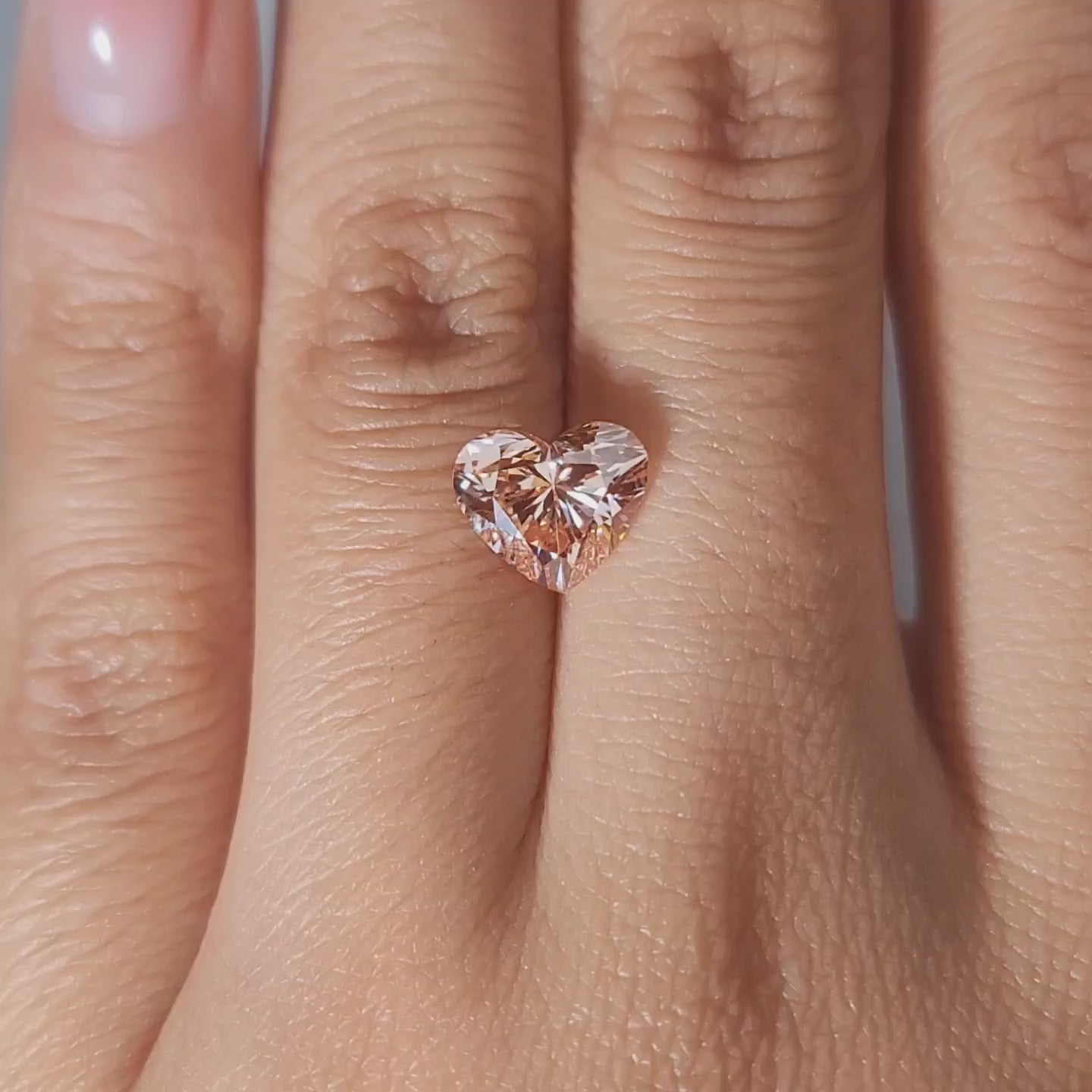 2.10ct Heart vivid pink diamond in warm handheld lighting