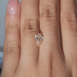 1.50ct Pear orange diamond showcased in soft candlelight glow