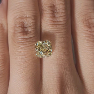 Finger-modeled video of 2.563ct yellow cushion diamond in ambient indoor light