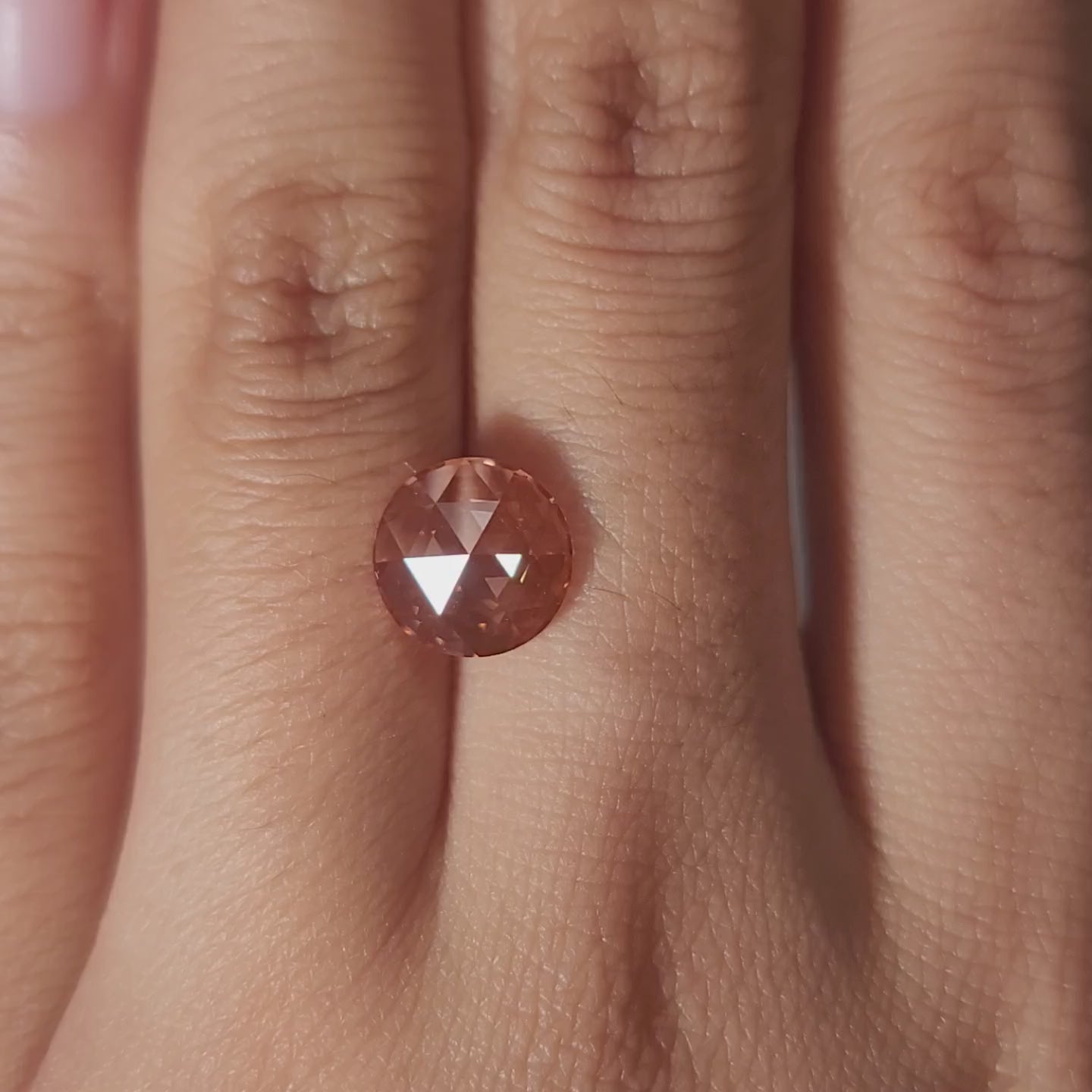 "Hand-modeled video of 2.53ct pink rose cut diamond in warm indoor lighting"