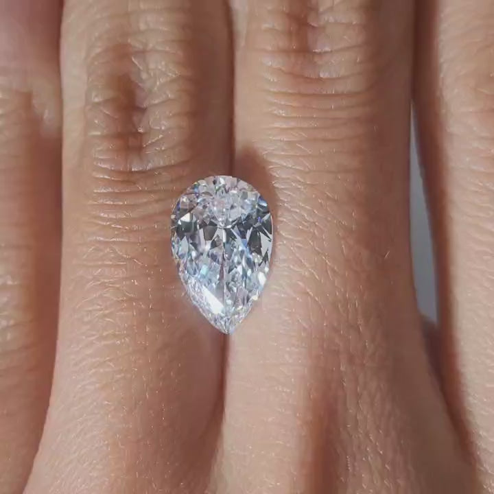 "Hand-modeled video of 3.011ct pear diamond in warm indoor lighting"