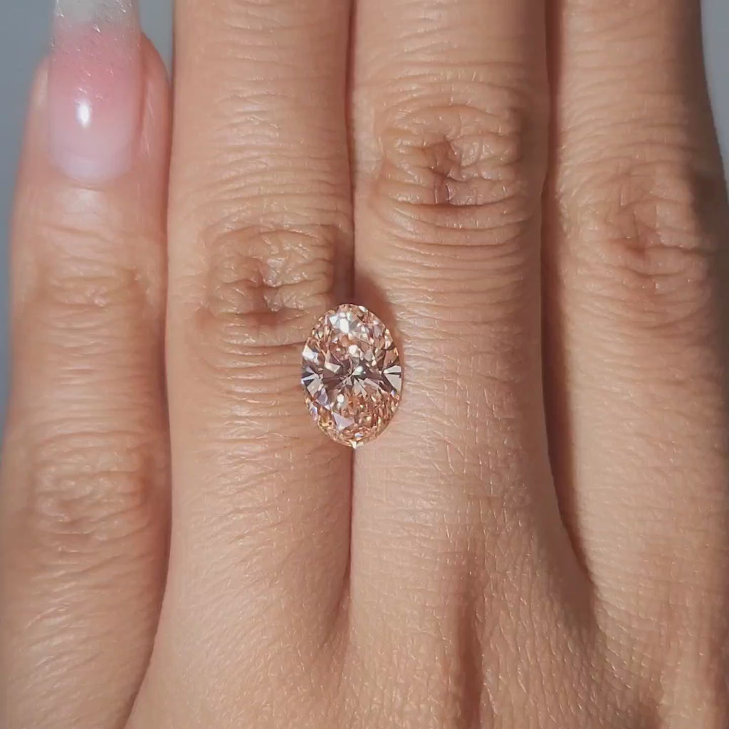2.54ct Oval pink diamond displayed in cozy golden lighting