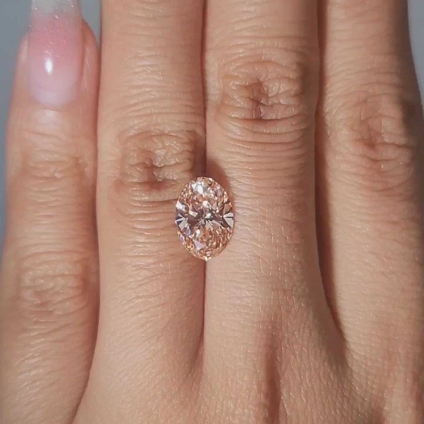 2.54ct Oval pink diamond displayed in cozy golden lighting