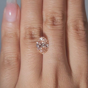 2.54ct Oval pink diamond displayed in cozy golden lighting